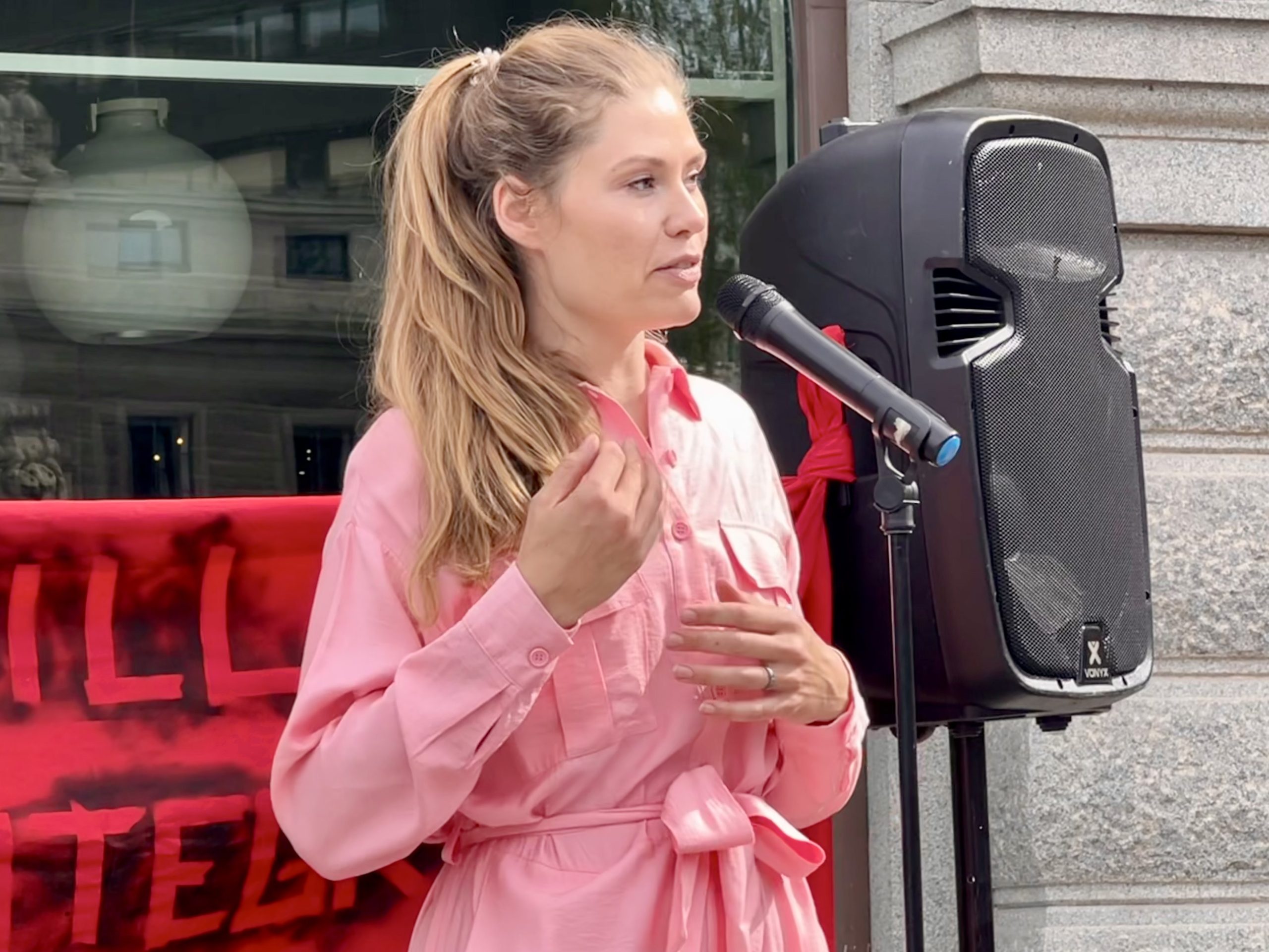 Katarina Stensson, partiledare för Piratpartiet, talar vid demonstration. En stor högtalare syns i bakgrunden.