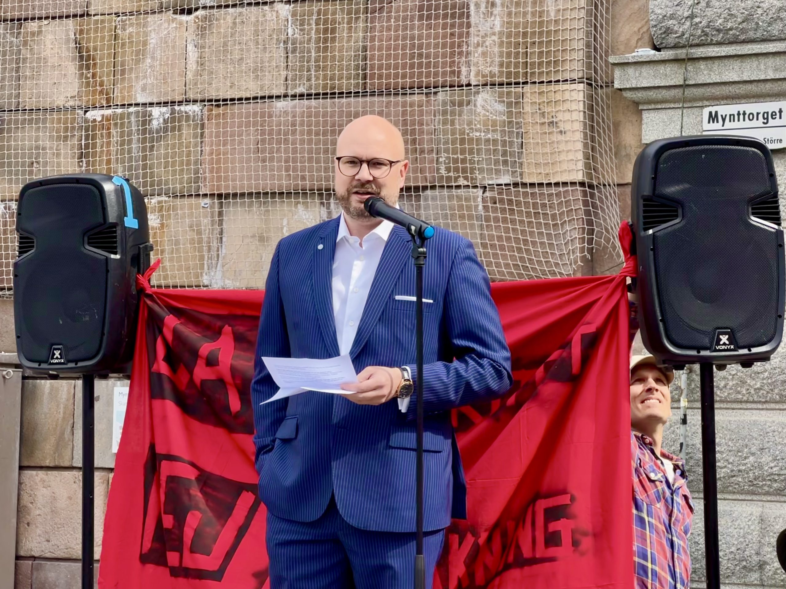 Peter Hellman (advokat på Integritetsbyrån) talar vid demonstration. En banderoll med texten "ja till integritet, nej till övervakning” syns i bakgrunden.